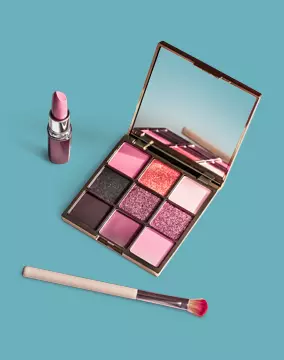 Pink eyeshadow palette, eyeshadow brush, and pink lipstick tube