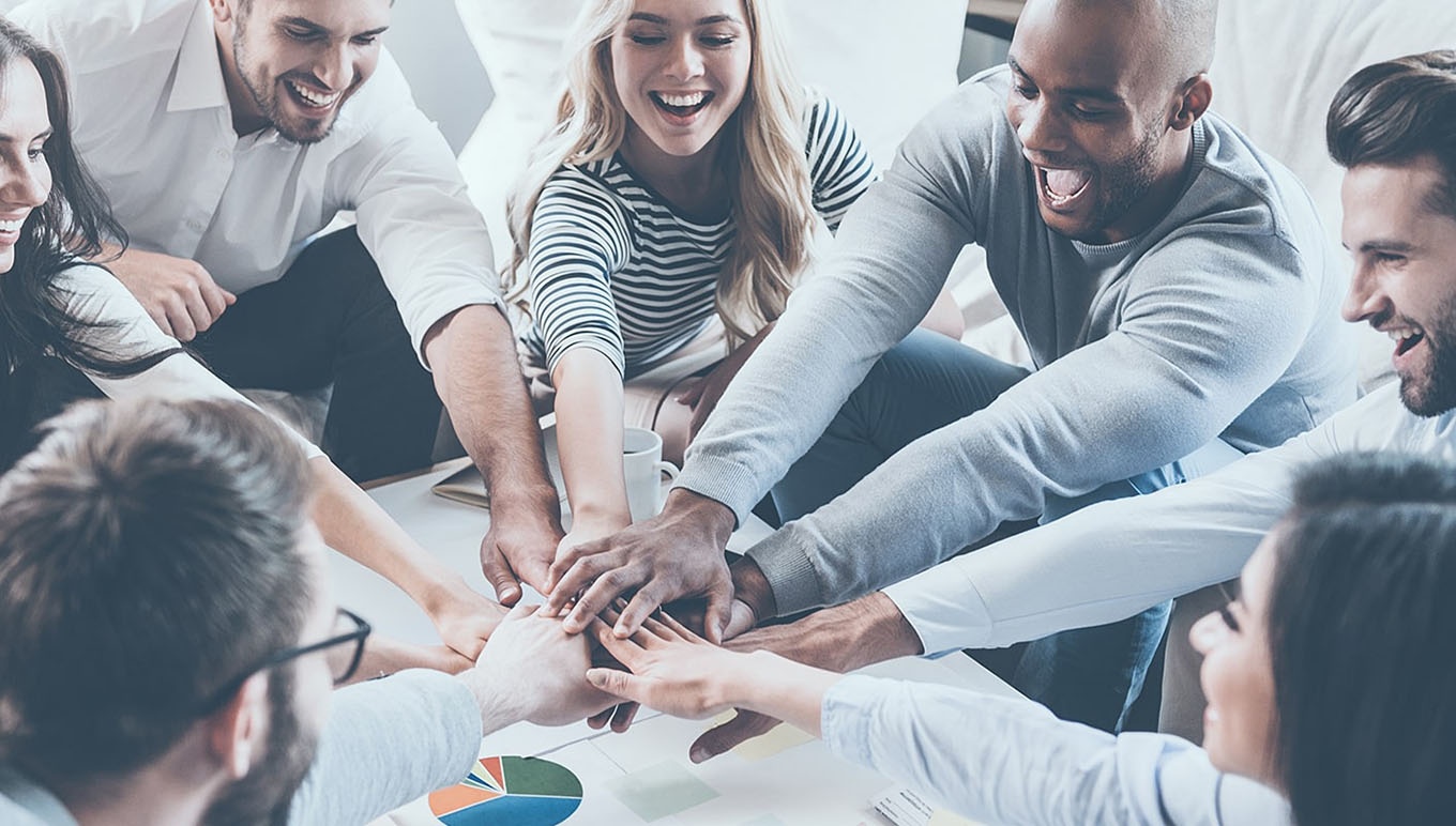 team with hands in on top of one another