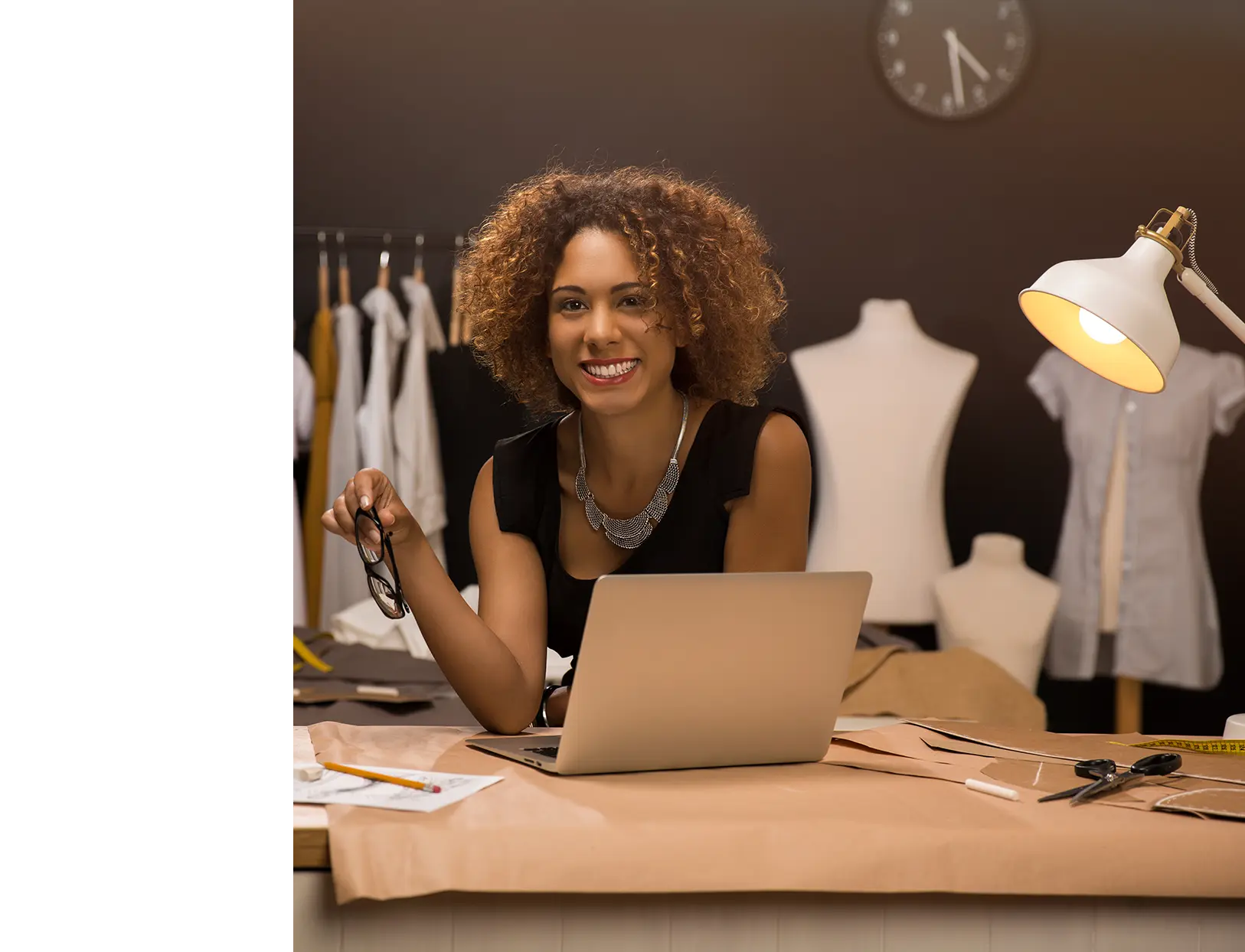 Mujer sonriendo detrás de un portátil