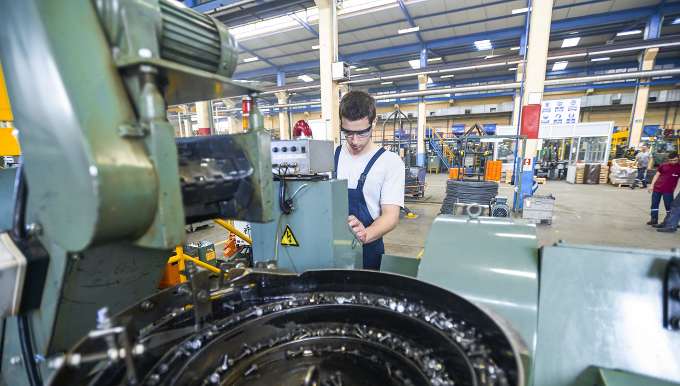 Maintenance worker operating manufacturing plant floor equipment
