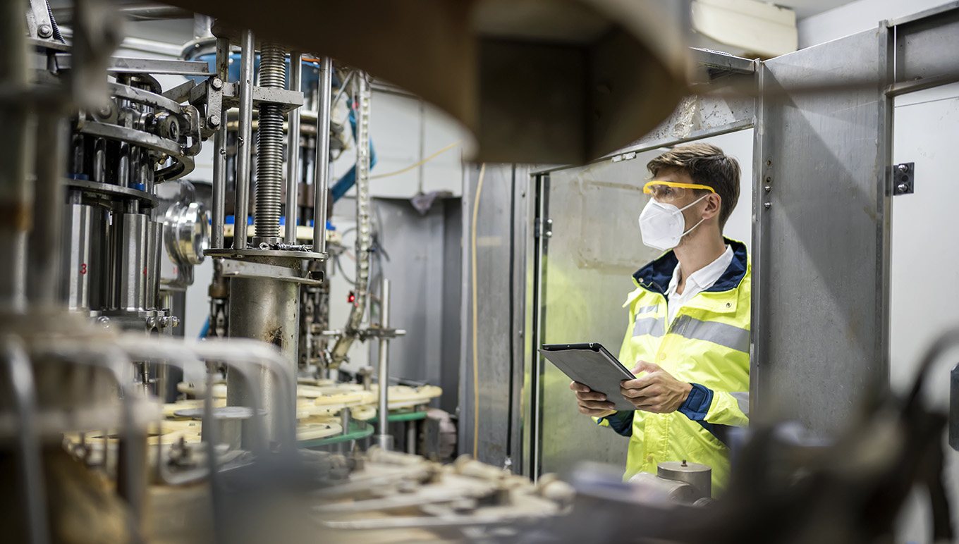 Factory working holding tablet and observing equipment
