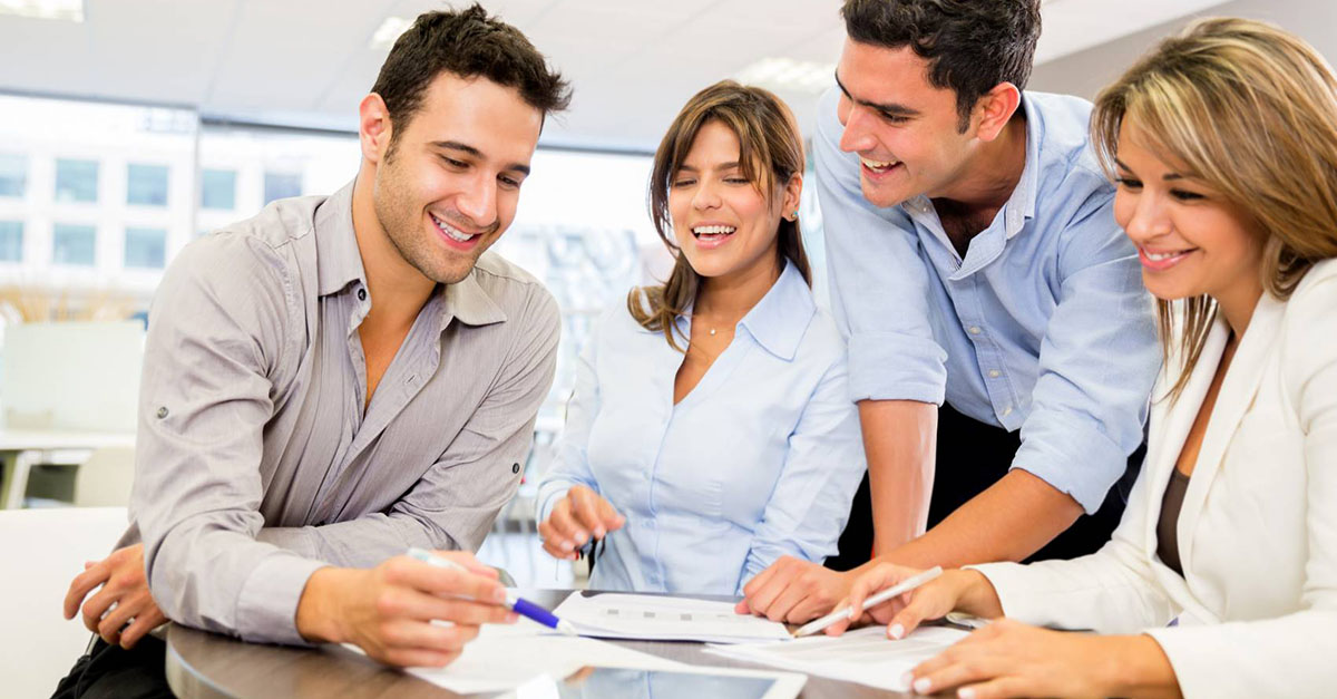 Team working around table in office environment.