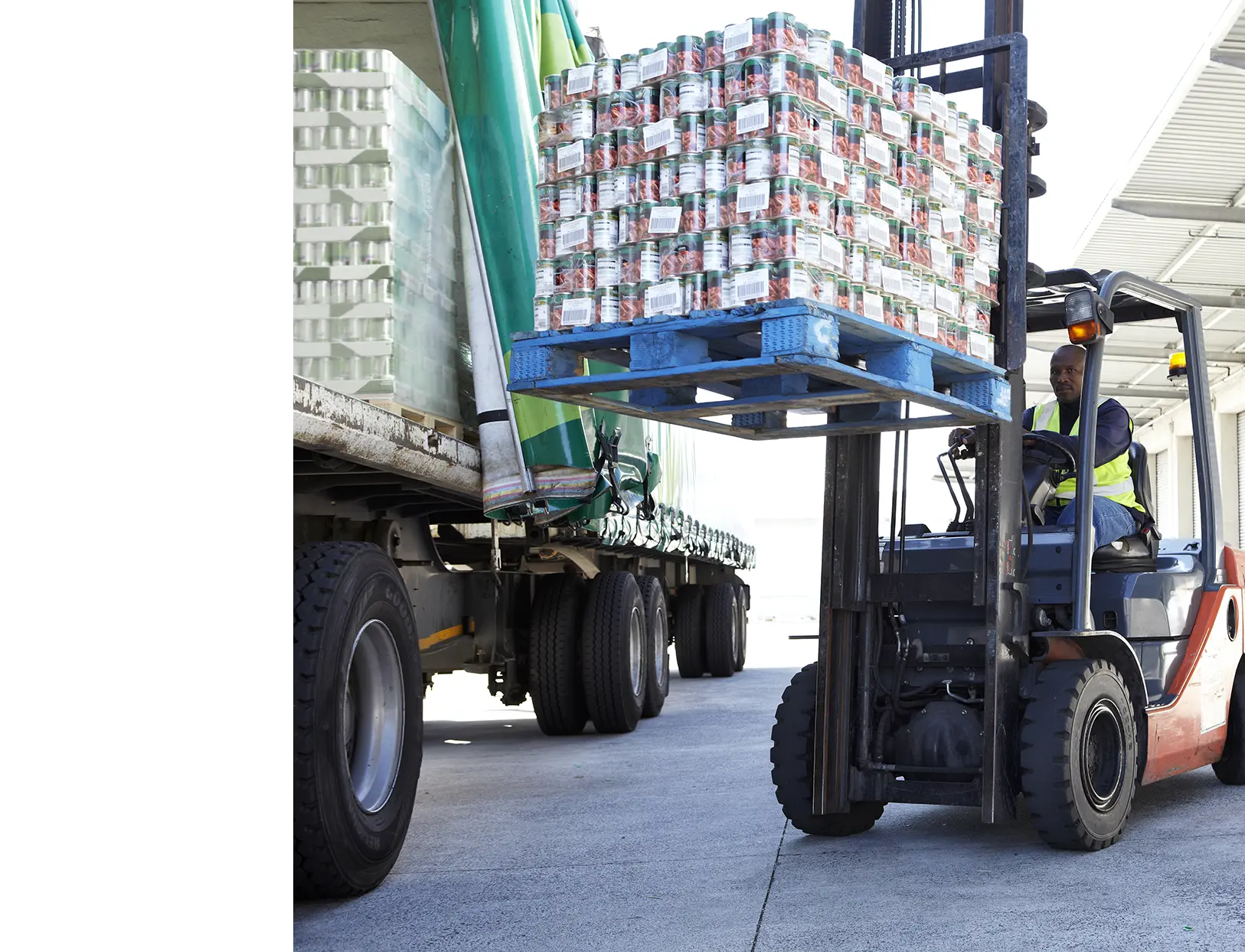 Met een vorkheftruck wordt een pallet met inventaris in een vrachtwagen gezet.