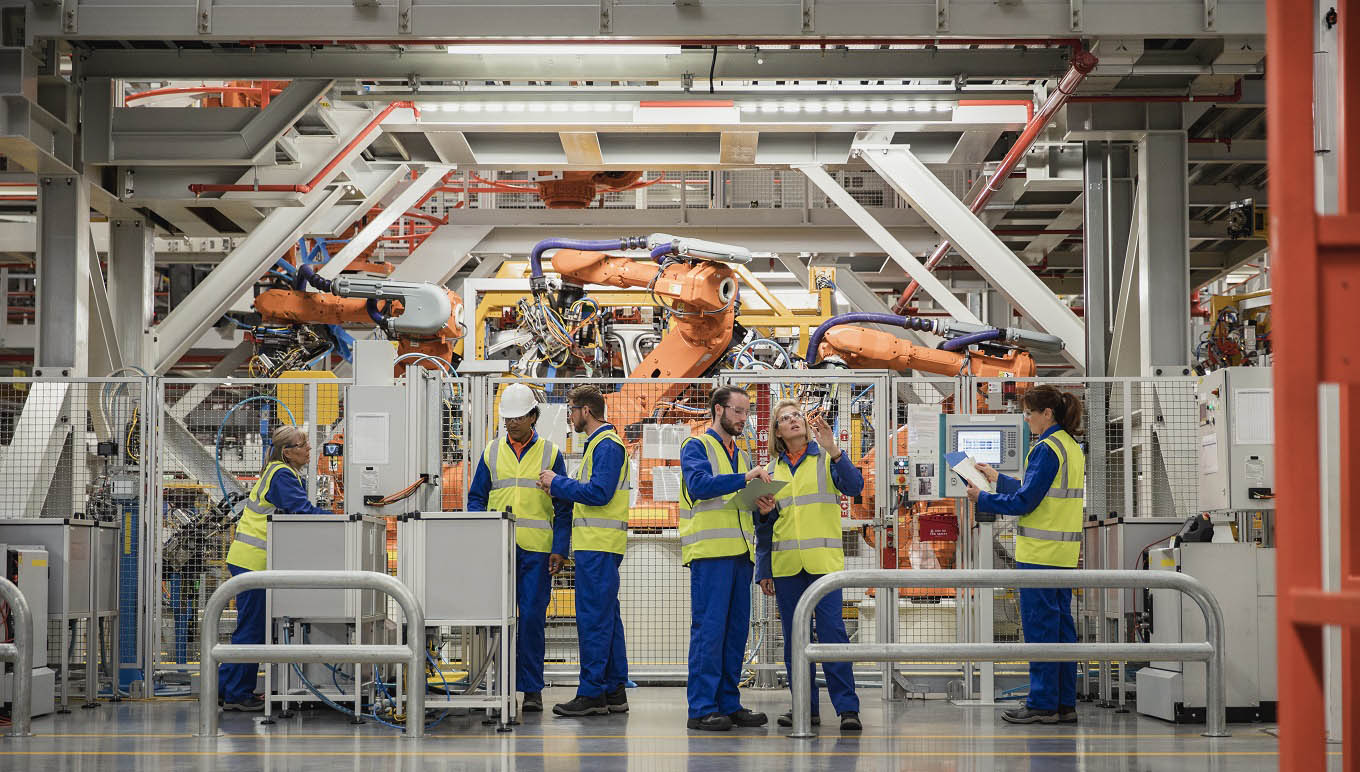 Workers on factory floor near machines and equipment