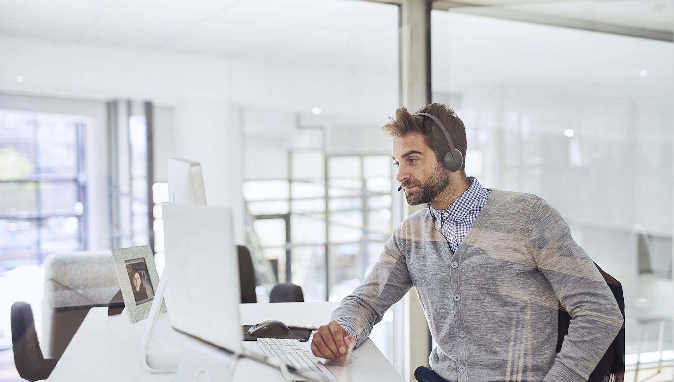 Man sitting in office in front of computer.