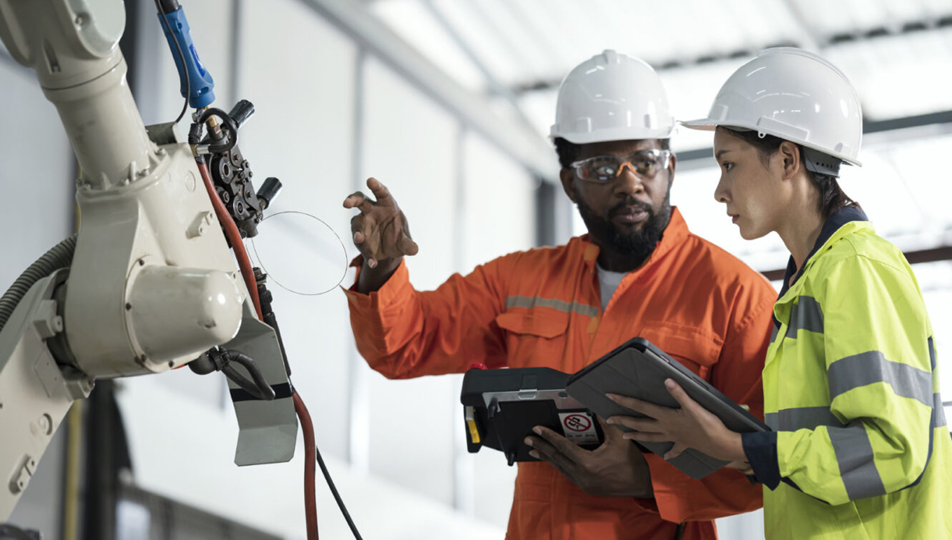 Shop floor workers reviewing equipment in factory