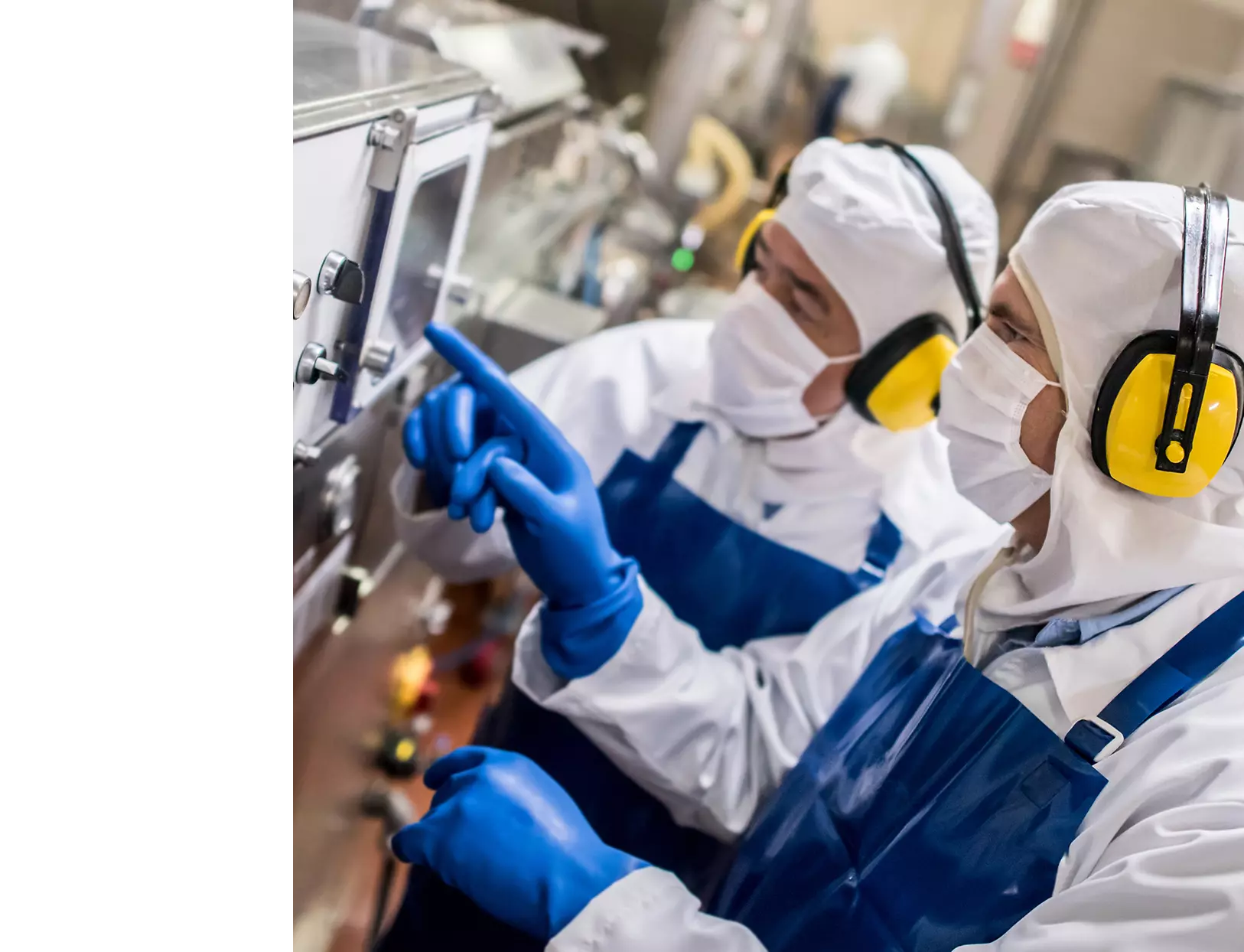 Deux hommes regardent une machine dans une usine.