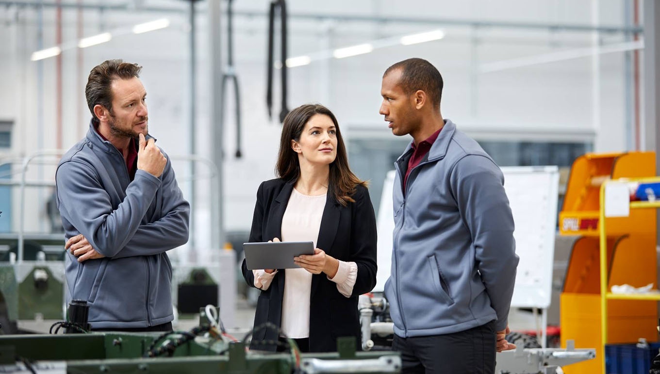 Woman holding tablet and chatting with two men