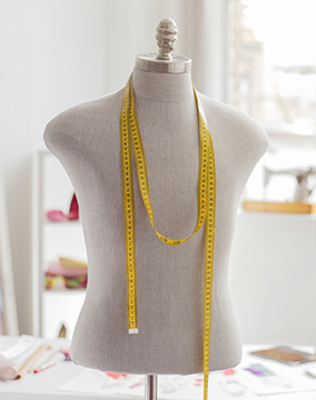 Mannequin with yellow tape measure on shoulders