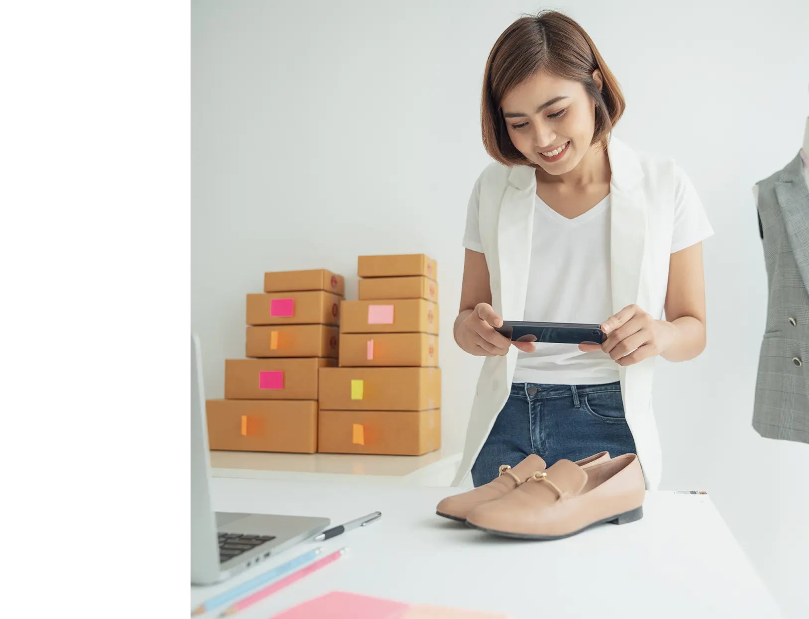 Woman taking a picture using her phone of a pair of shoes.