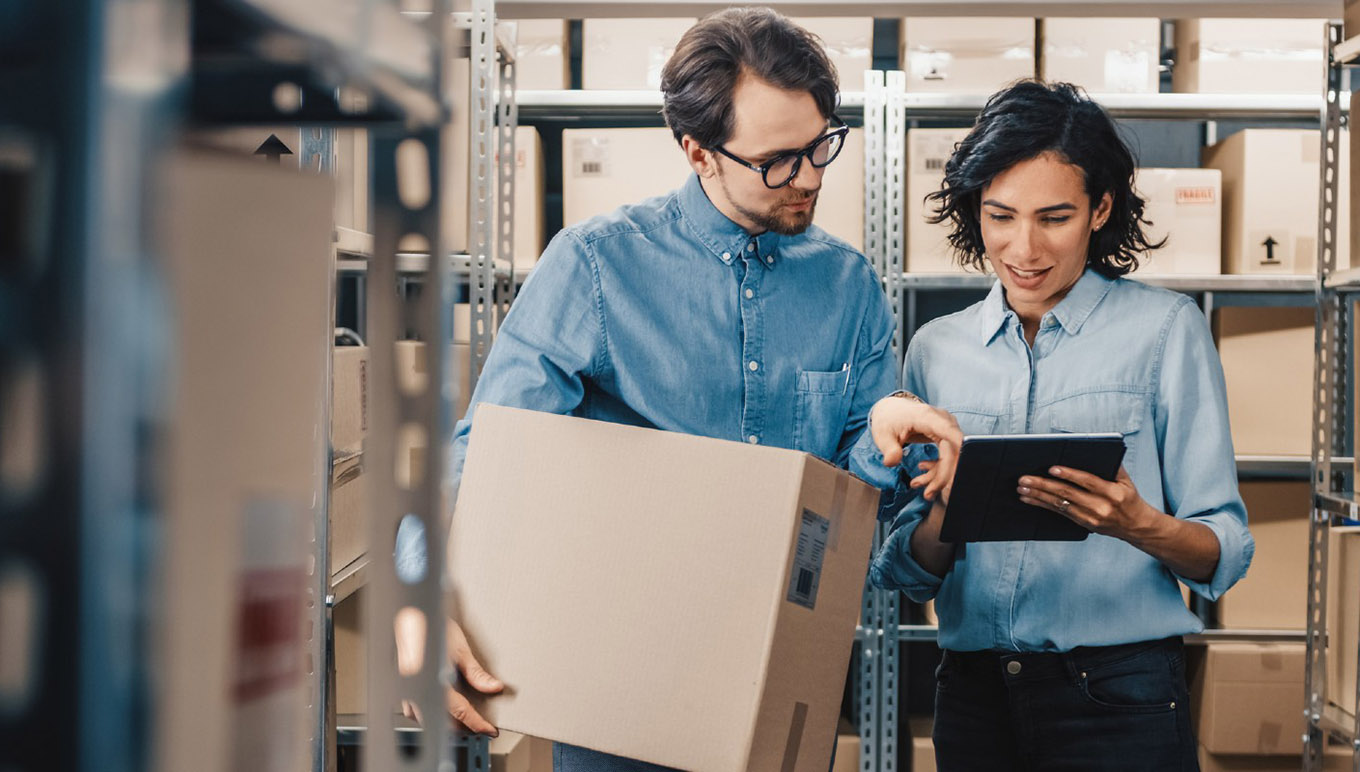 man holding box and woman looking at tablet