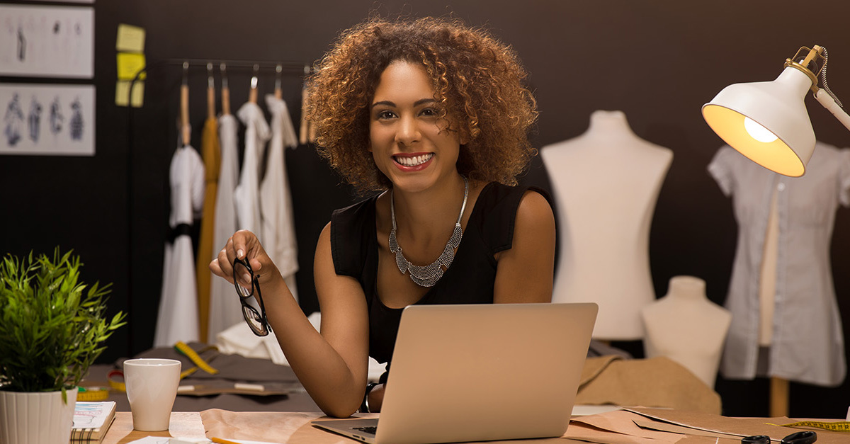 Fashion designer woman at desk with laptop