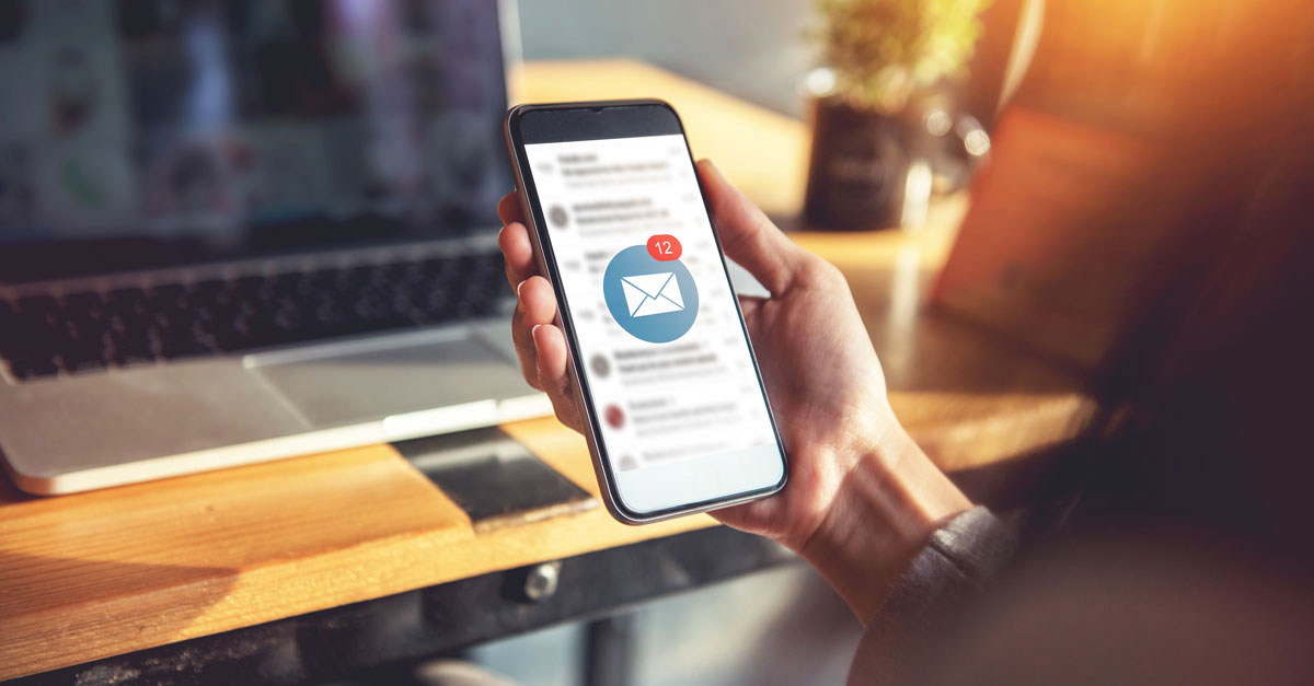 Person hält ein Smartphone mit Nachrichten.
