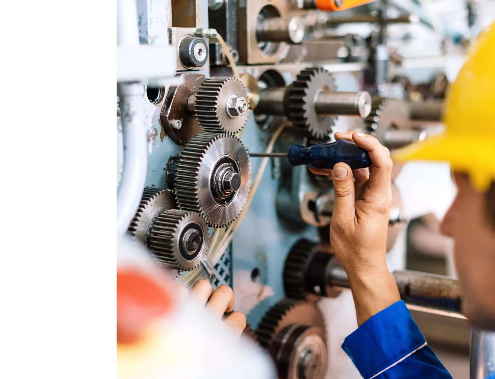 A man using a screwdriver to repair a machine.