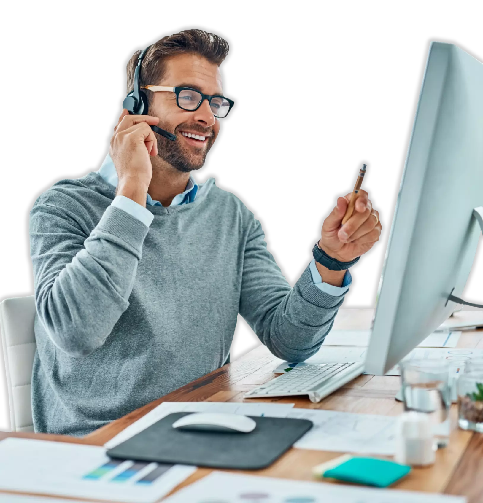 Man sitting at a computer desk using headset microphone.